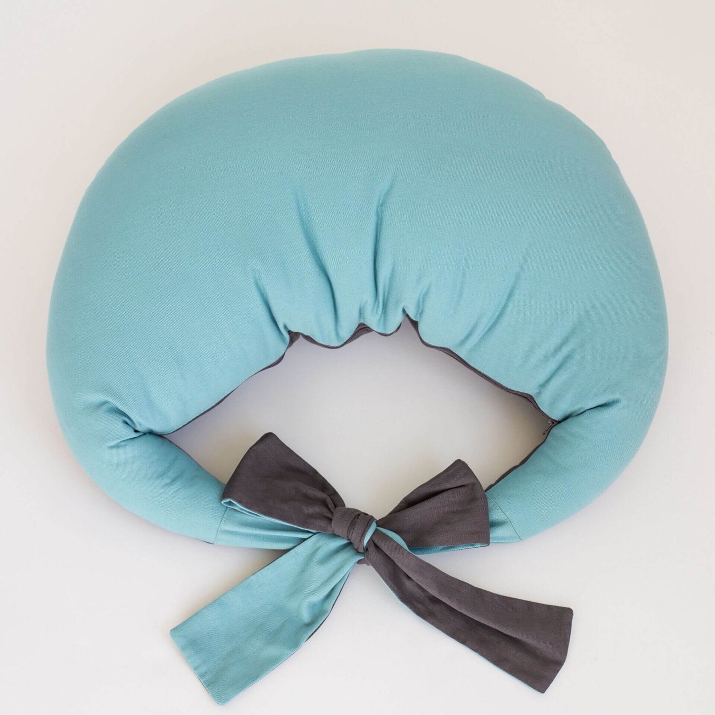 Feeding pillow in reef blue and charcoal, viewed from above showing waist tie detail.