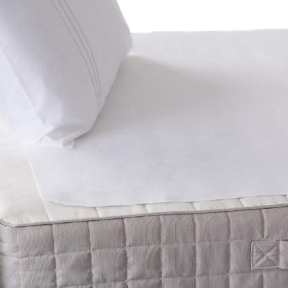 Hippychick Flat Tencel Mattress Protector shown on top of a bed with quilted mattress and white bedding.