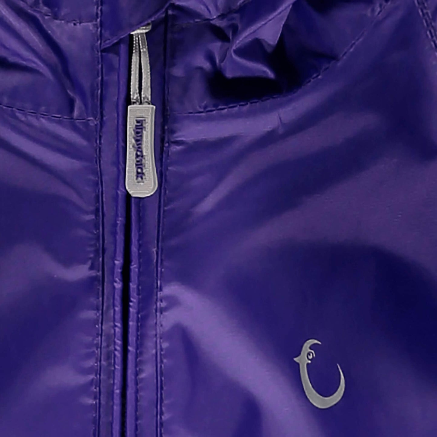 Close-up of a deep purple Packasuit zipper with a small brand logo near the bottom right corner.