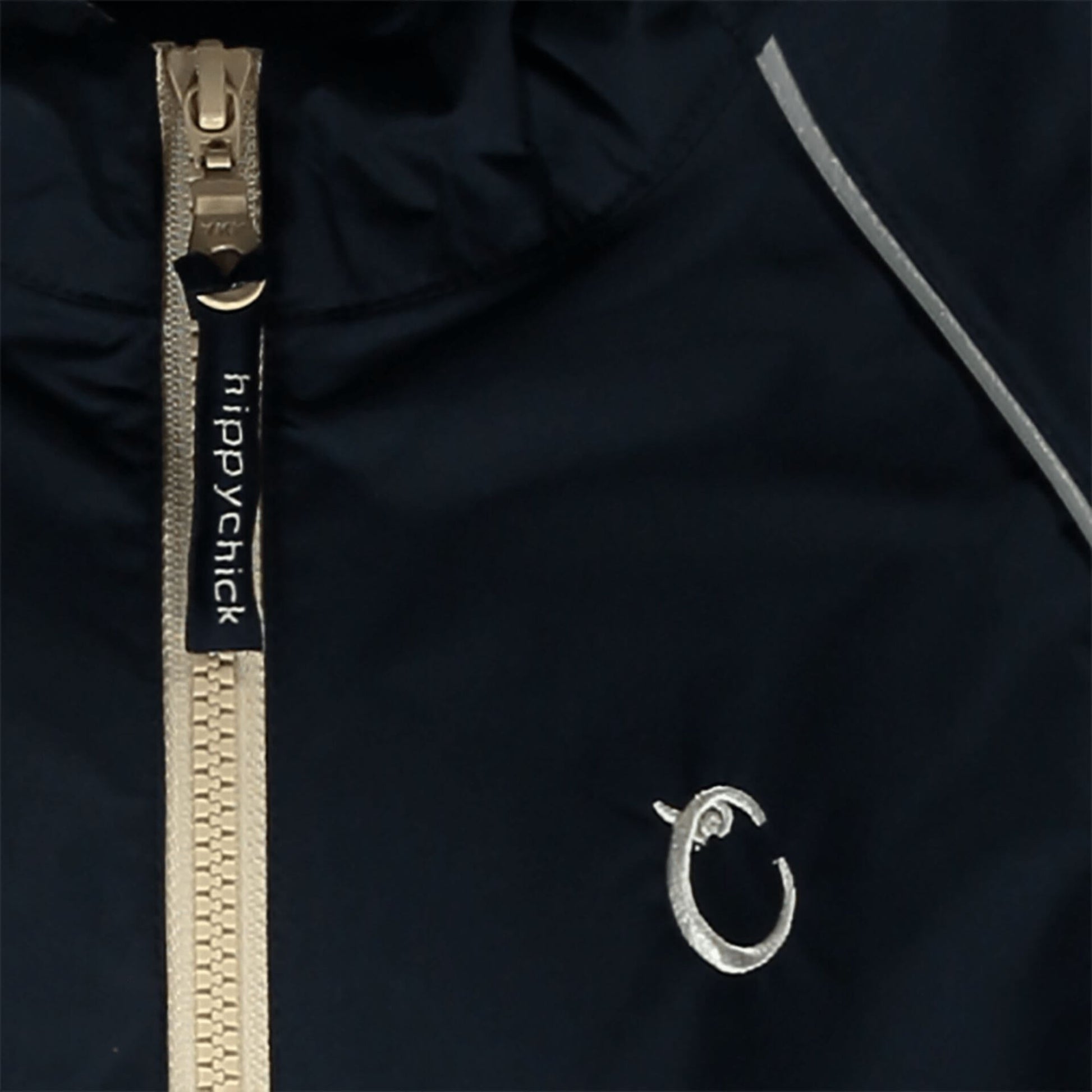 Close-up of navy waterproof fabric with beige zip, showing reflective piping and embroidered Hippychick brand logo.