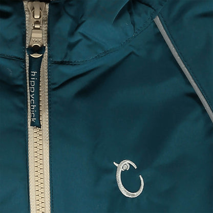 Close-up of teal waterproof fabric with beige zip, showing reflective piping and embroidered Hippychick brand logo detail.