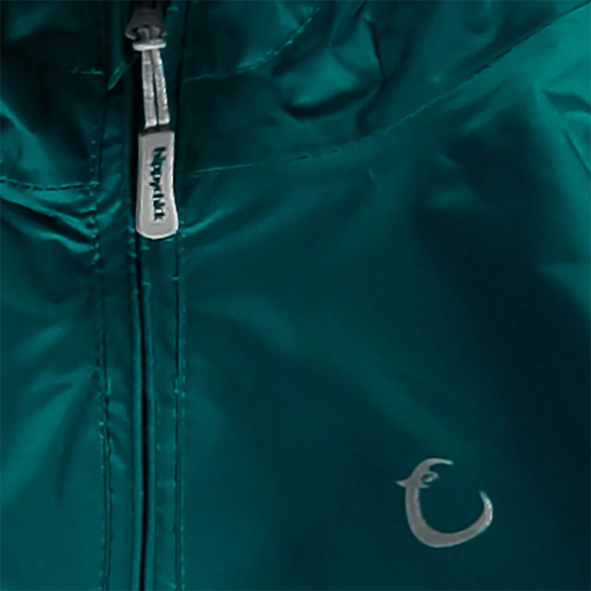 Close-up of green waterproof packasuit fabric showing Hippychick zip pull and reflective brand logo.