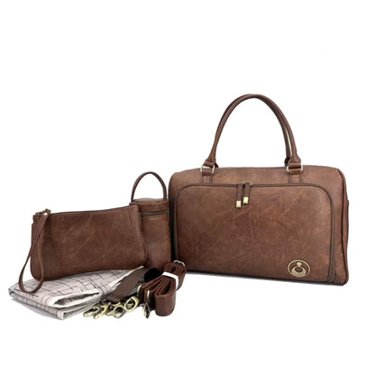 Satchel Changing Bag in Redwood Chestnut displayed with matching accessories, including padded change mat, insulated bottle holder, and small purse.