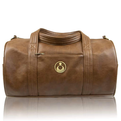 Isoki Kingston Duffle Bag in Redwood showing soft faux-leather finish, gold logo emblem, and front zip pocket.