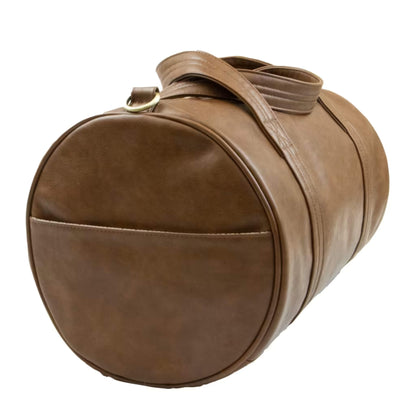 End view of a brown duffle changing bag with an open side pocket and rounded design.