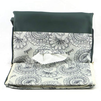 Green change mat clutch opened flat to show the built-in change mat with floral lining and central wipes access slot.