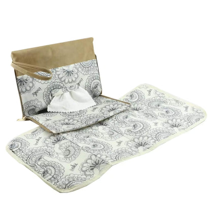 Full-length view of the beige changing mat fully unfolded, displaying the floral printed lining and soft padded sections.