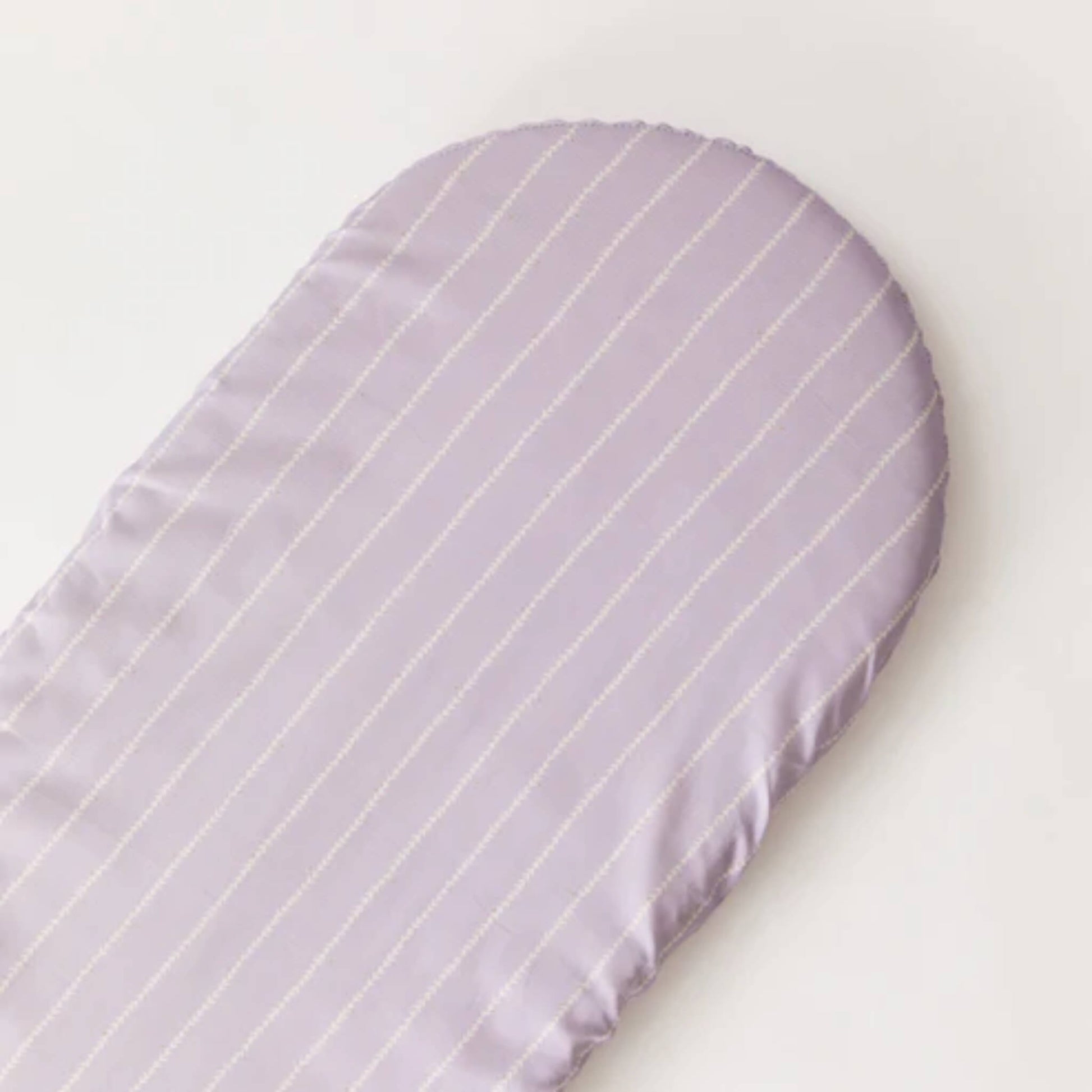 A lilac fitted sheet laid flat, showing a rounded mattress shape and evenly spaced stitched vine stripes.