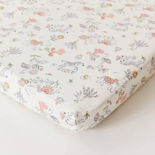 Kabode Organic Cotton Fitted Sheet with a soft cream base and a delicate boho animal and floral print, shown neatly fitted over a mattress with elasticated edges.