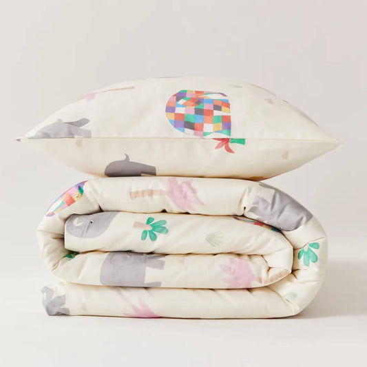 Kabode Elmer organic cotton duvet cover and pillowcase set folded neatly, showing soft cream fabric with colourful Elmer patchwork elephants and gentle nature motifs.