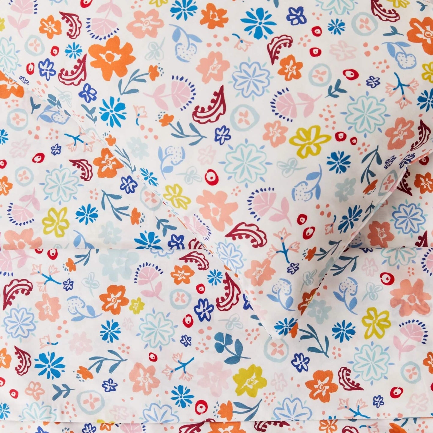 Detailed fabric close-up highlighting  repeating floral motif with hand-drawn flowers and foliage in soft contrasting colours on light cotton.
