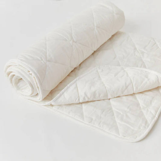 Kabode toddler wool duvet folded and rolled, showing quilted organic cotton outer and soft natural wool filling on a light background.