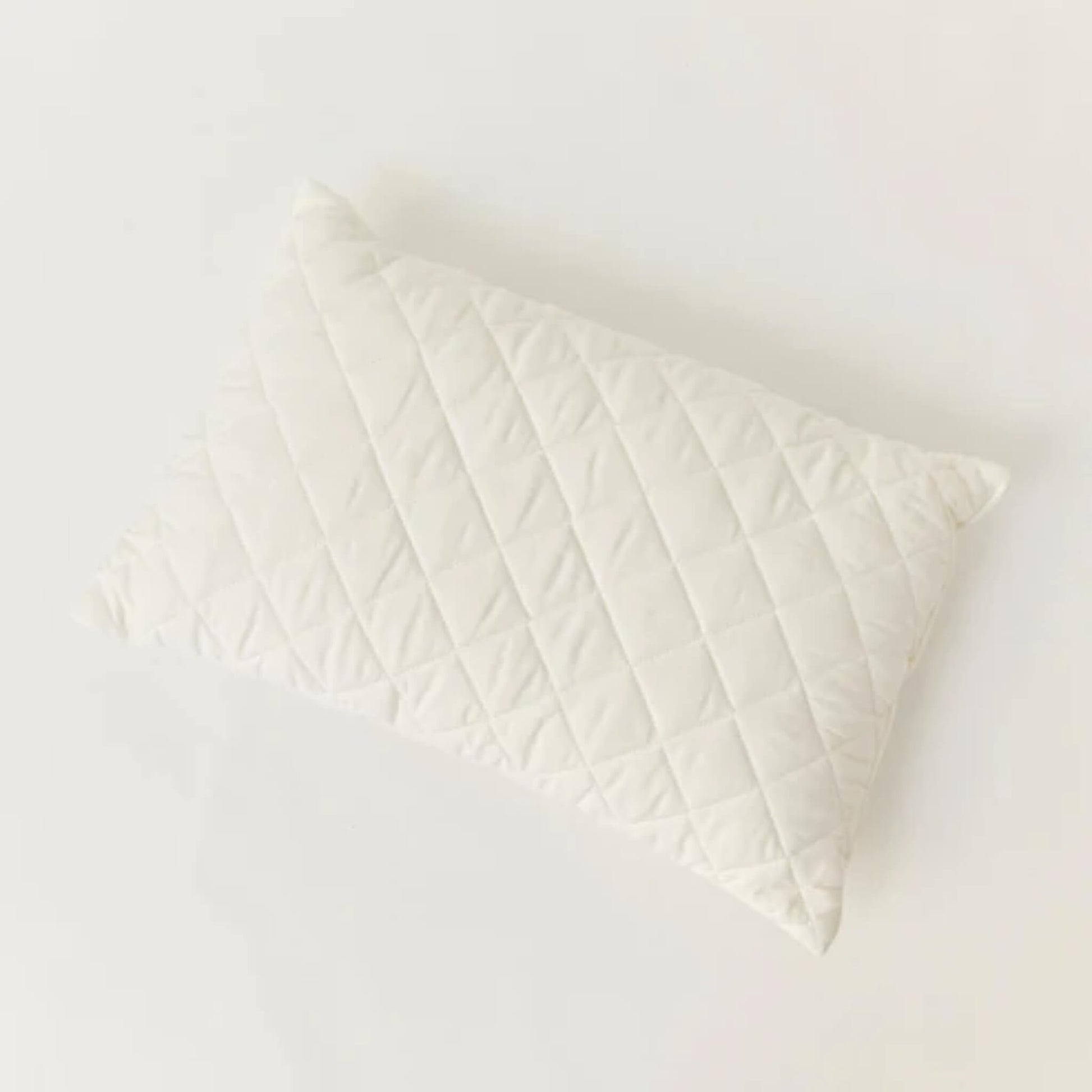 Kabode Wool Toddler Pillow shown from above, featuring a quilted organic cotton cover with diamond stitching on a soft neutral background.