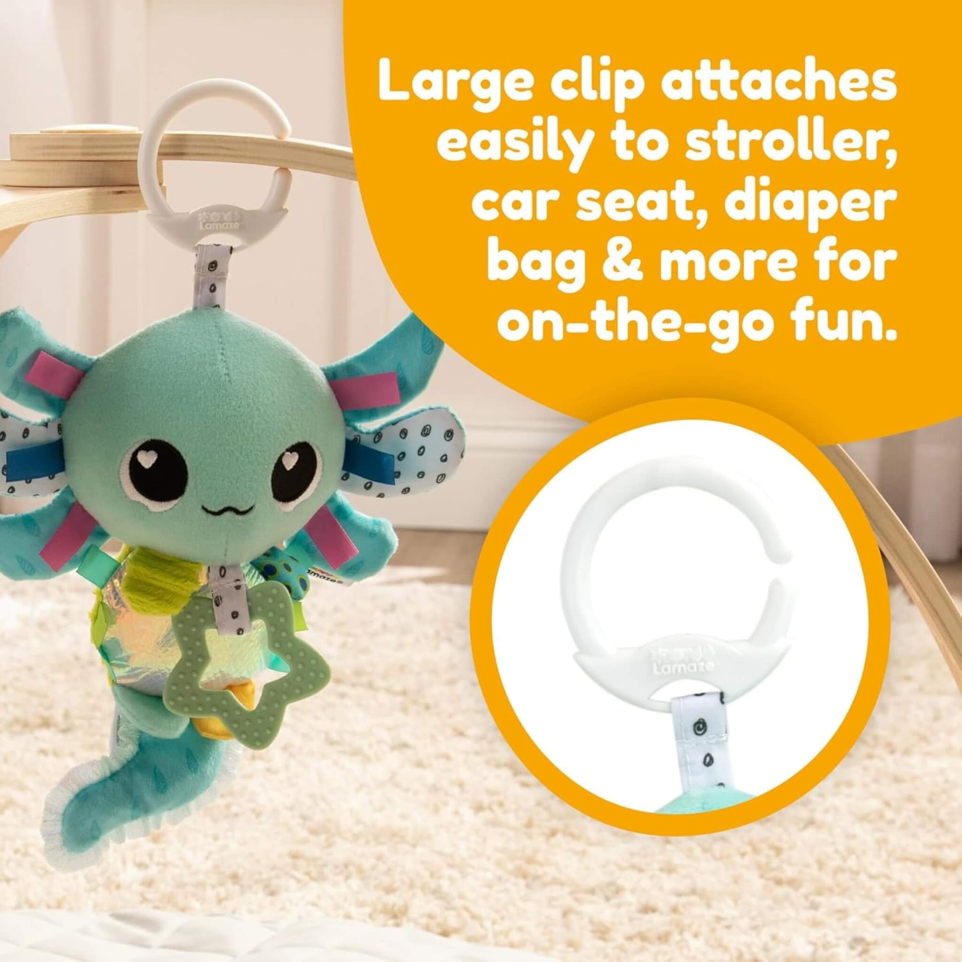 Plush axolotl toy hanging from a white clip on a wooden play arch, with printed text explaining its clip-on feature for strollers or car seats.