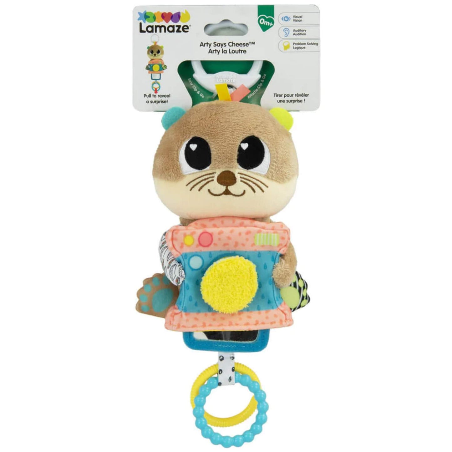 Plush otter baby toy in retail packaging with colourful textures, camera-shaped body, and white clip attachment visible at the top.
