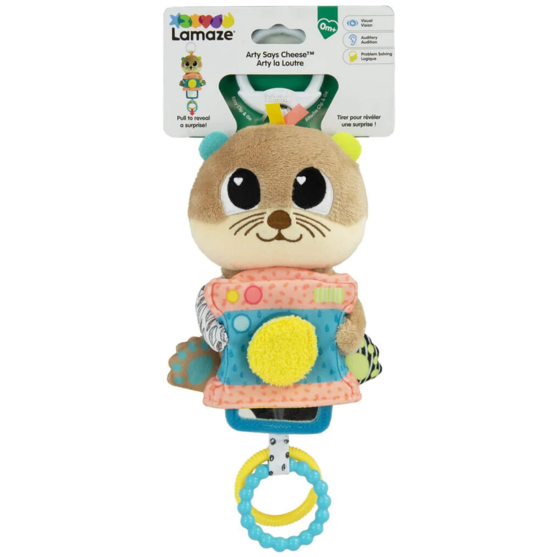Plush otter baby toy in retail packaging with colourful textures, camera-shaped body, and white clip attachment visible at the top.