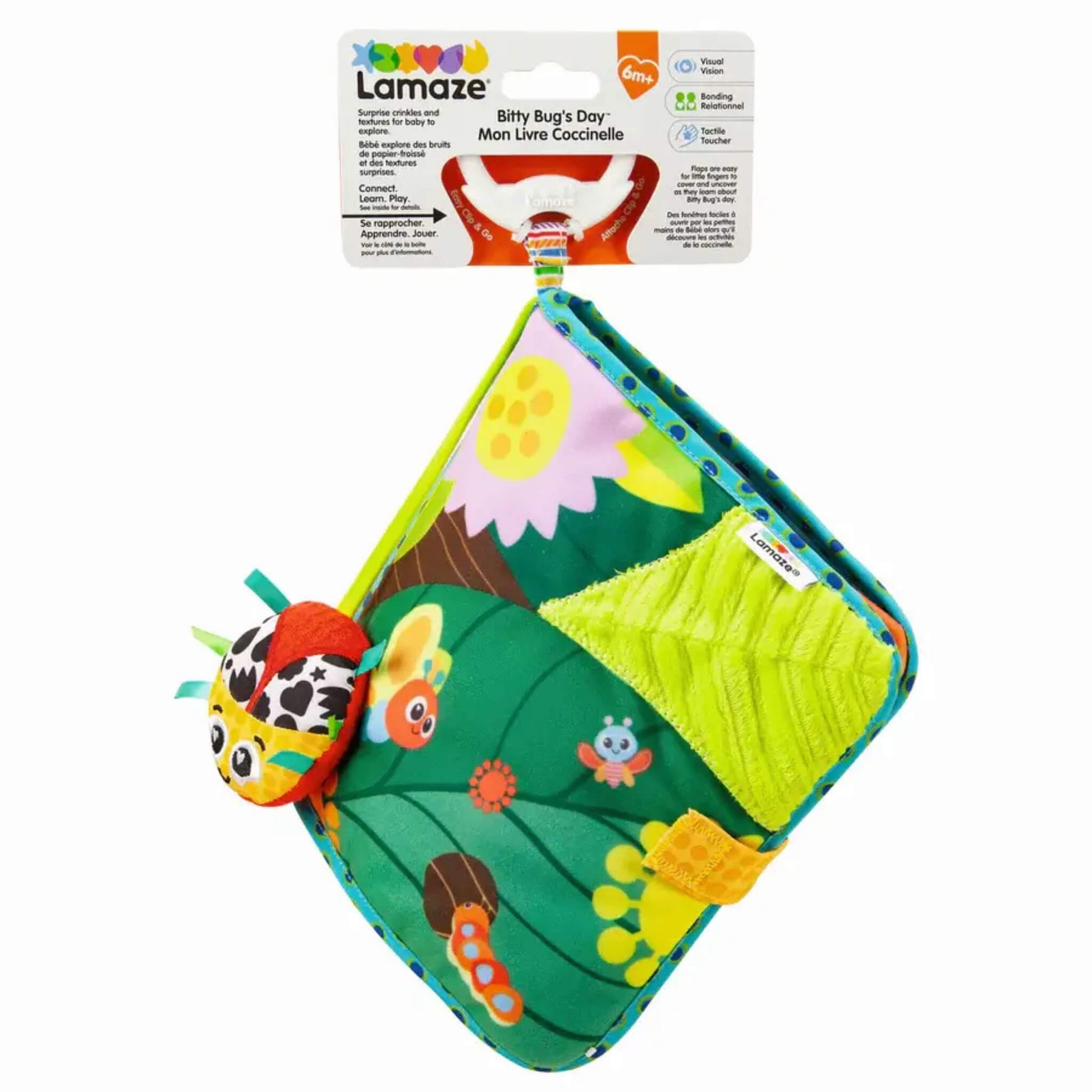 Fabric baby book with bright garden patterns, attached ladybird toy, and Lamaze packaging displaying age guidance for 6 months and up.