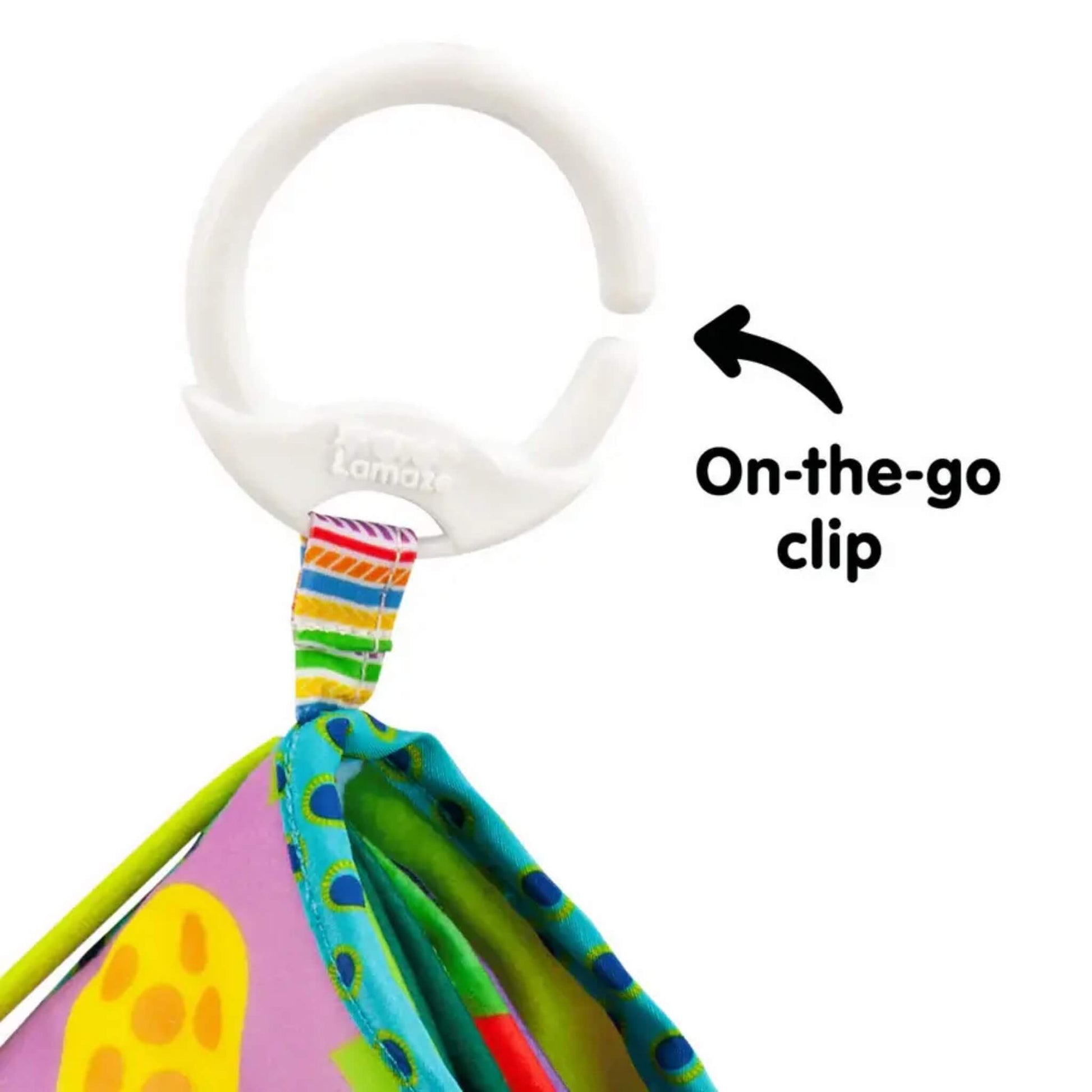 Close-up of a white plastic clip attached to the corner of a fabric baby book, designed for securing to prams or bags.