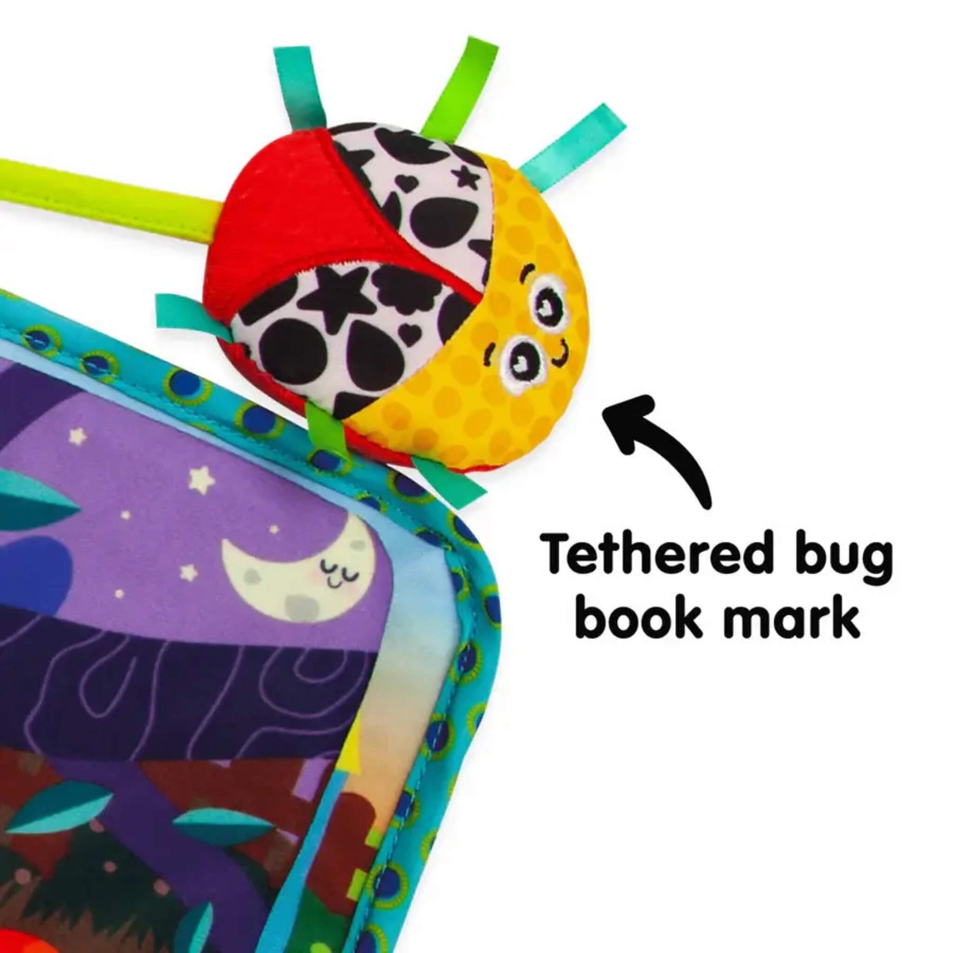 Tethered ladybird toy with yellow face, red wings, and black-and-white patterned shell, attached to the book by a green cord.