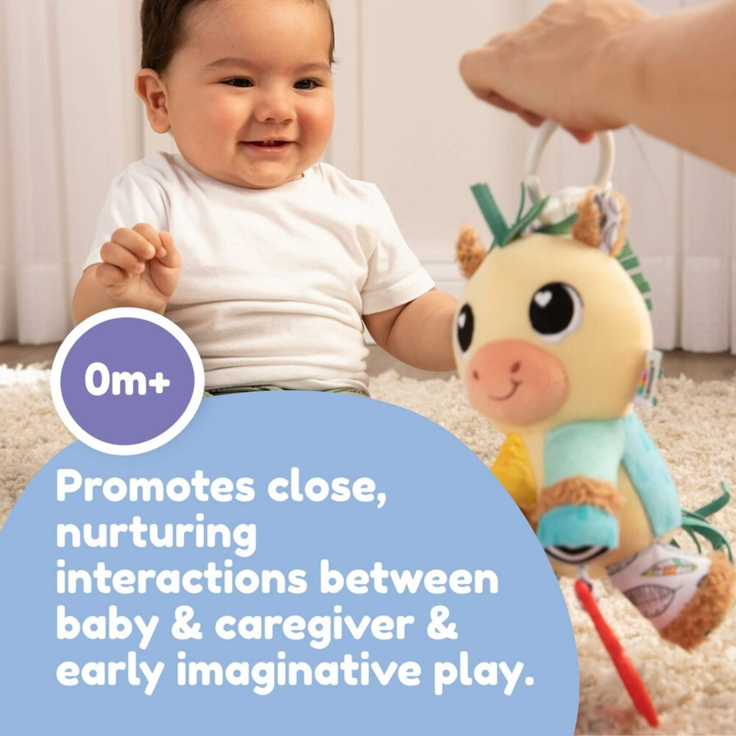 Baby smiling while interacting with the plush horse toy, held by a mother during playtime.