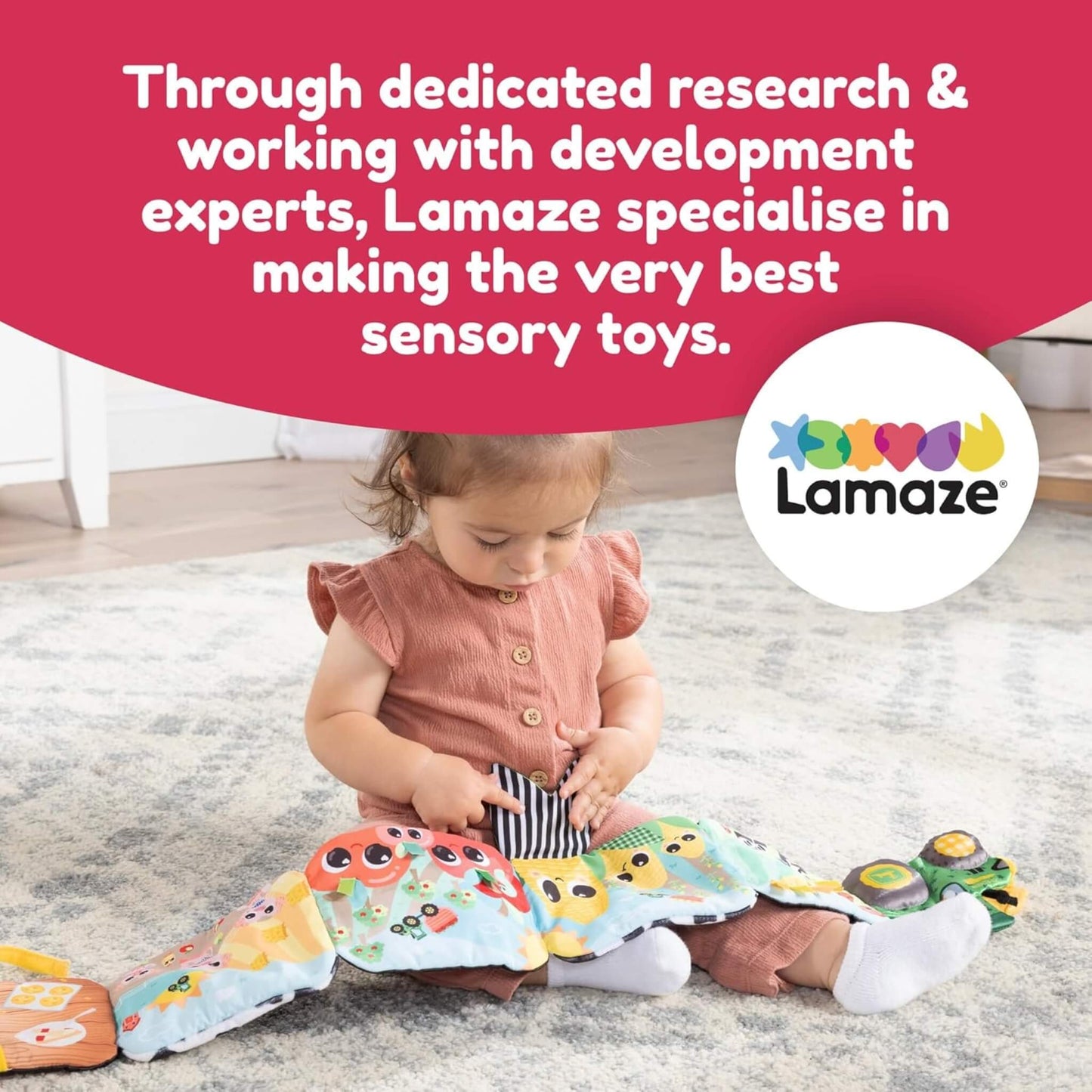 Toddler sitting on a rug, playing with a soft fabric book featuring cows, crops, and tractor illustrations that encourage visual and tactile discovery.