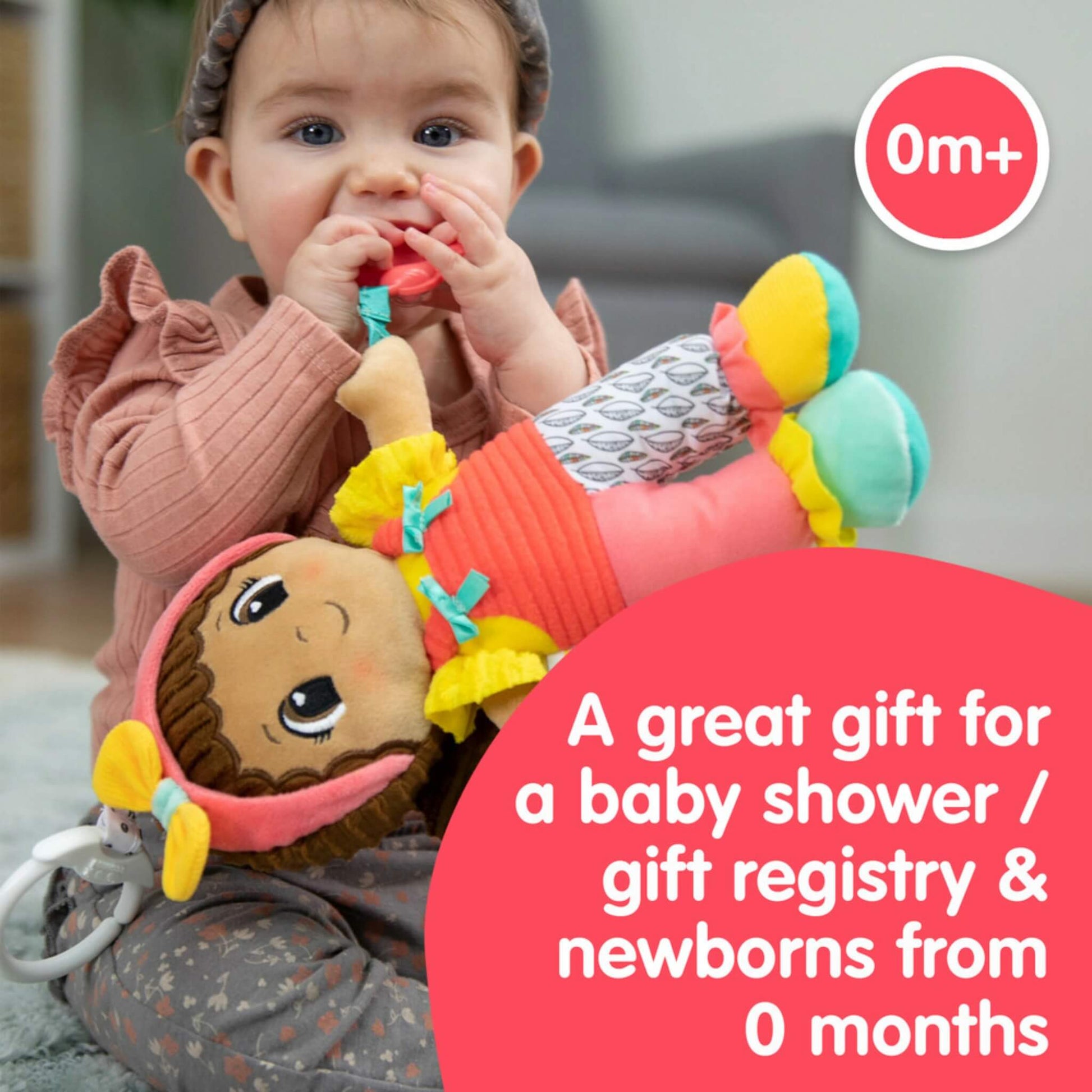 Baby sitting and chewing on a Lamaze doll’s rattle toy, with text describing it as a great gift for newborns and baby showers