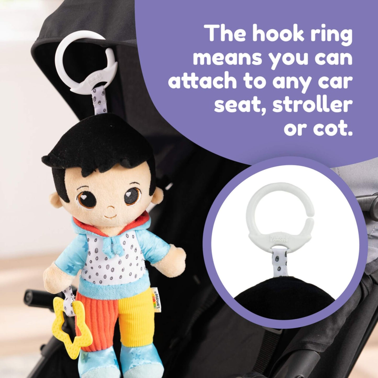Soft doll shown attached to a stroller using its white hook ring, with text describing how it clips easily to a pram, cot or car seat.