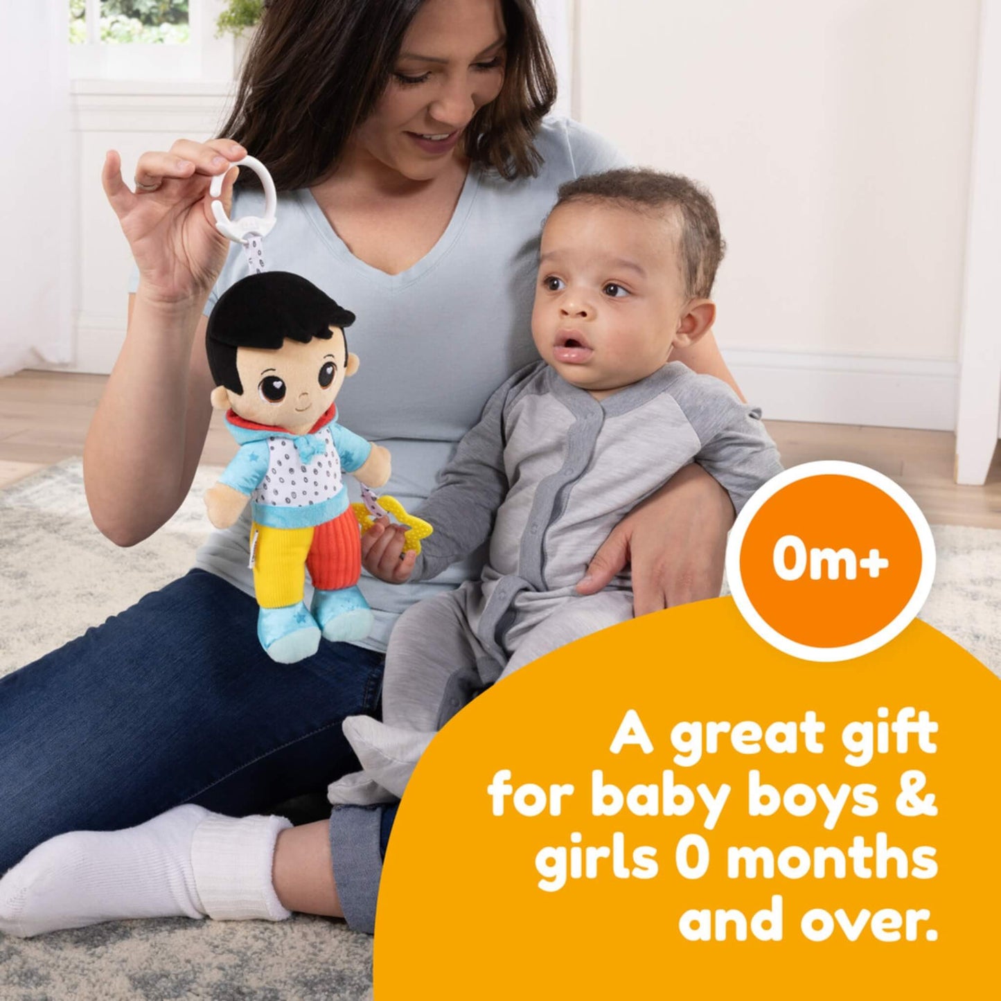 Parent sitting with baby on a rug, showing the baby reaching for a bright doll while text describes it as a great gift for newborns.