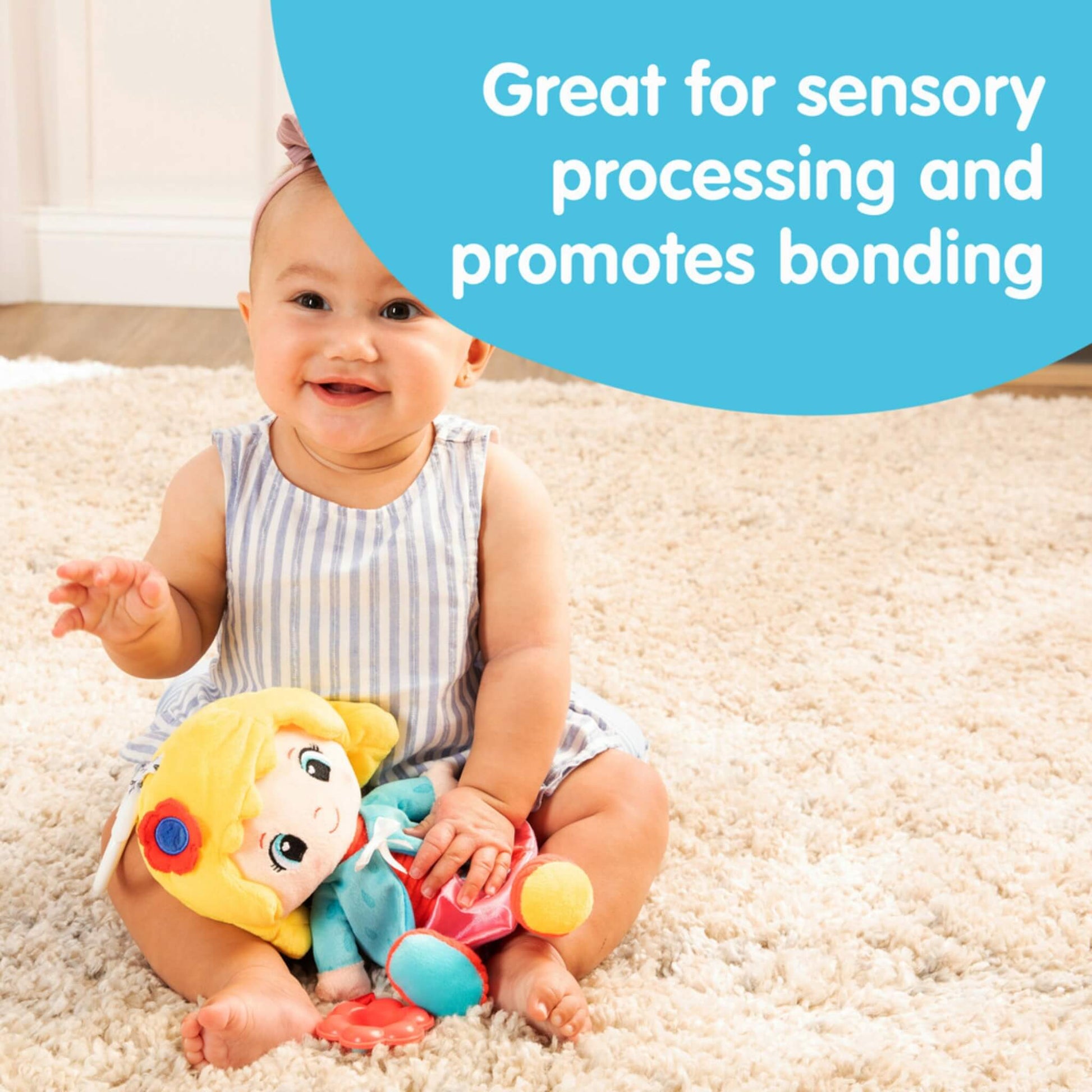 Baby sitting on a cream rug smiling with a soft doll in their lap while text describes how the toy supports sensory processing and bonding.