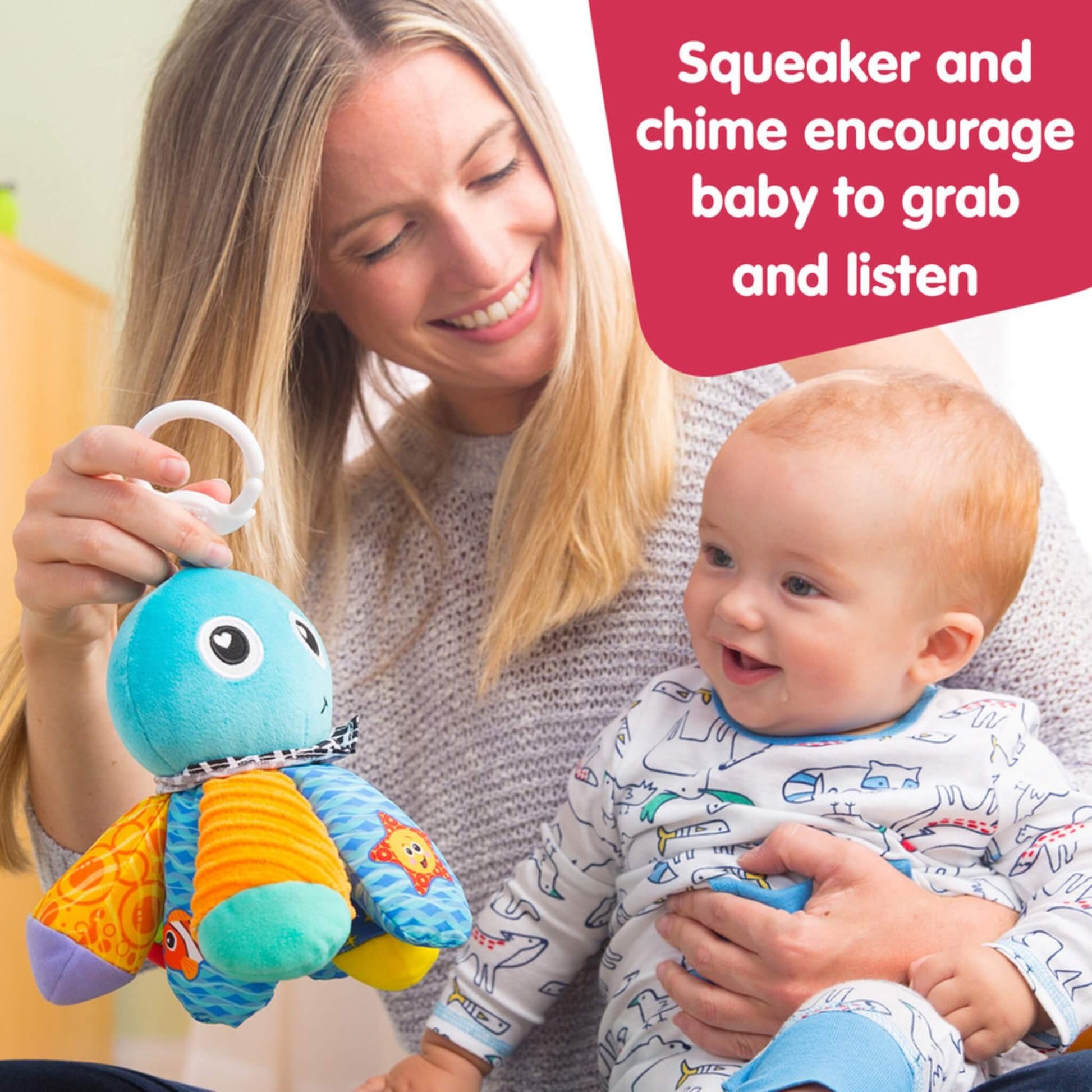 Mother smiling while holding a plush octopus toy in front of her baby, encouraging the baby to reach for it during playtime.