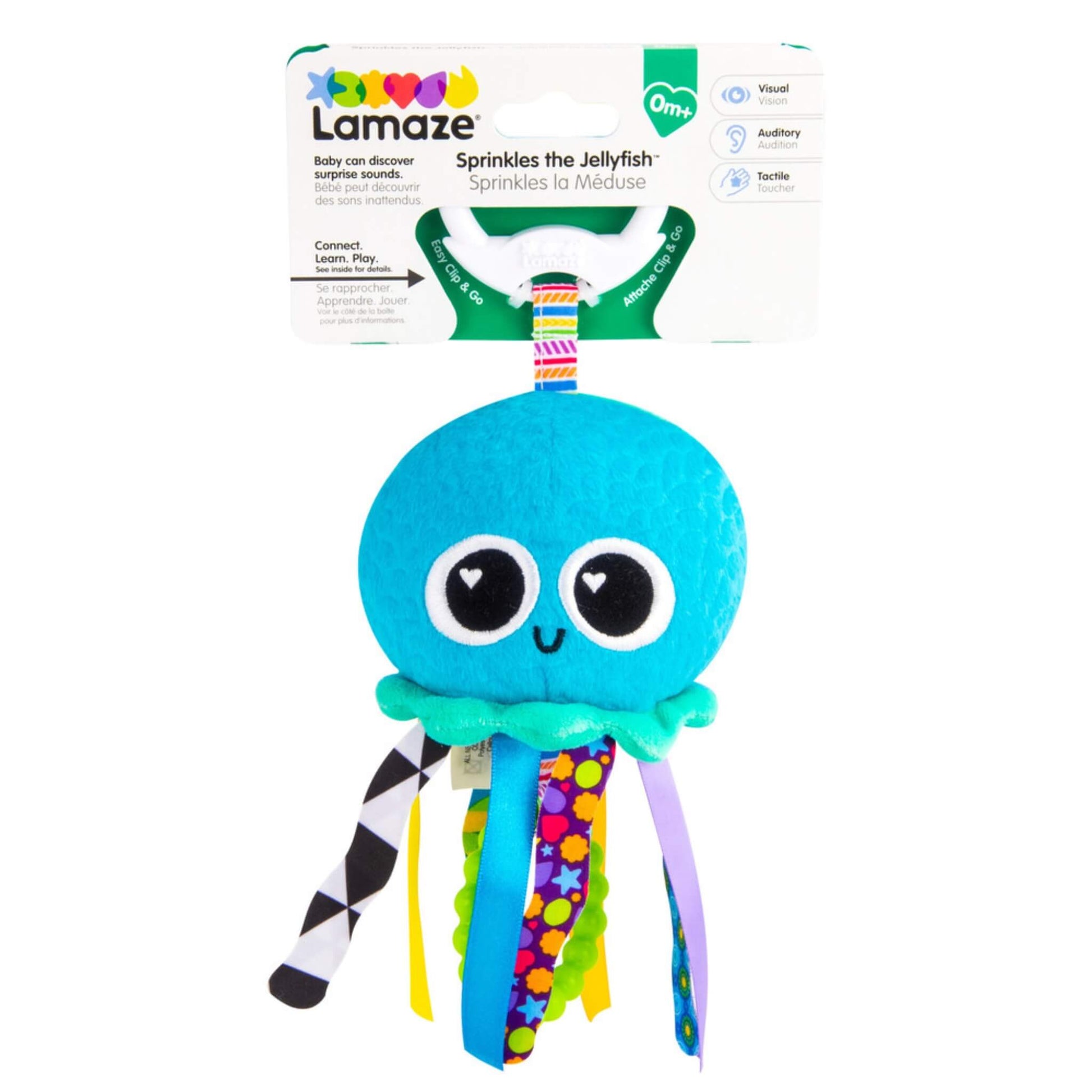 Jellyfish toy displayed in its retail packaging, showing the Lamaze branding, sensory icons for vision, hearing and touch, and a clear view of the multicoloured ribbons that support early sensory development.