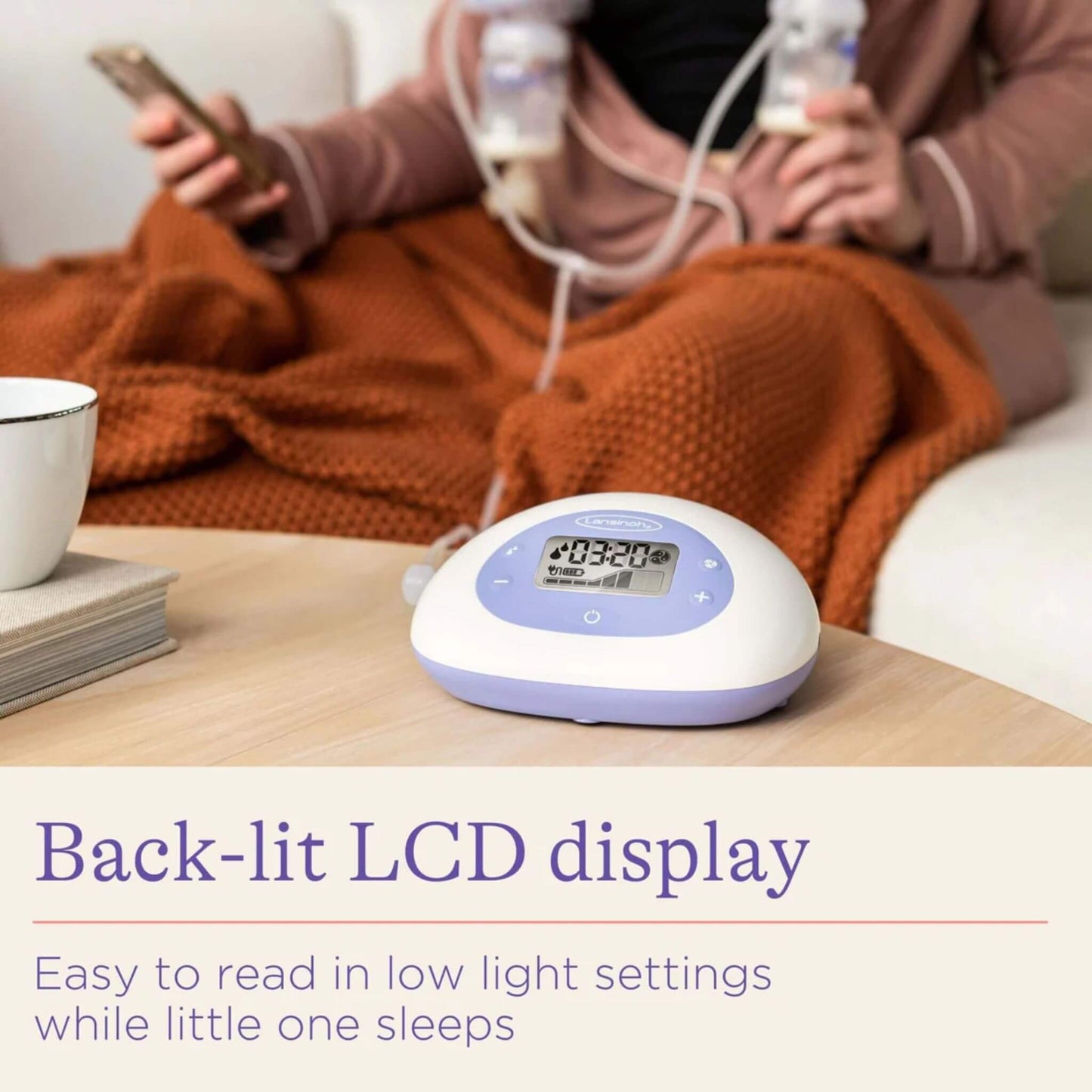 Breast pump control unit on a table with back-lit LCD screen glowing, while a mother relaxes nearby expressing milk, showing quiet operation for night use.