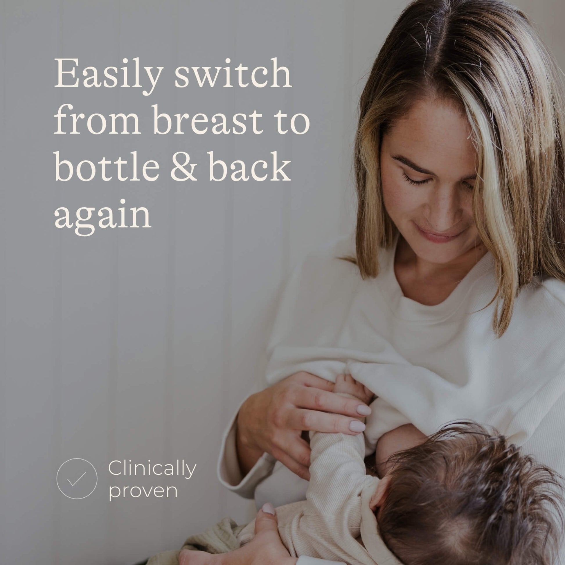 Mother breastfeeding a baby while seated indoors, showing a natural feeding position and close parent-baby interaction.