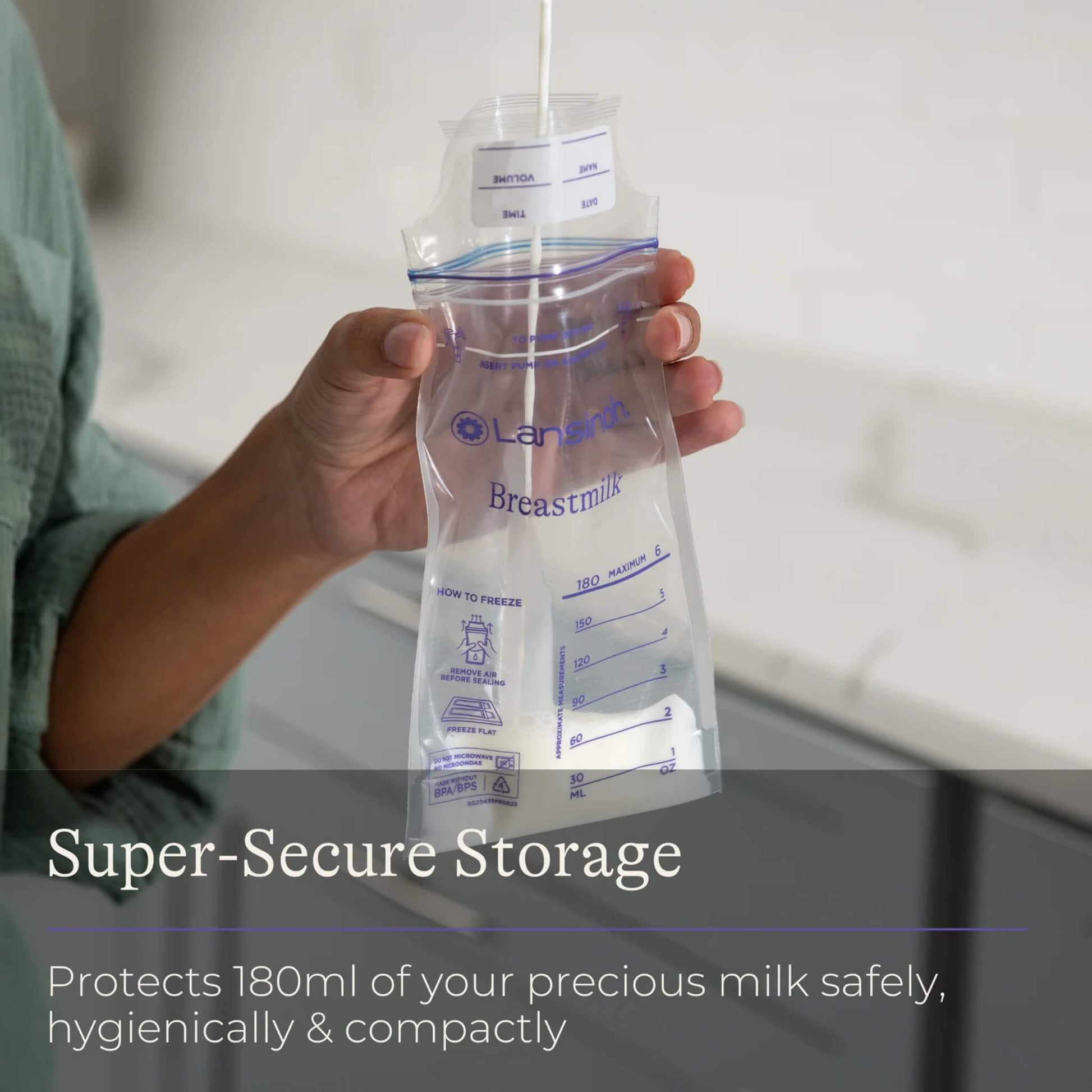 Hand holding an open breastmilk storage bag while milk is poured inside, showing measurement markings and secure upright filling.