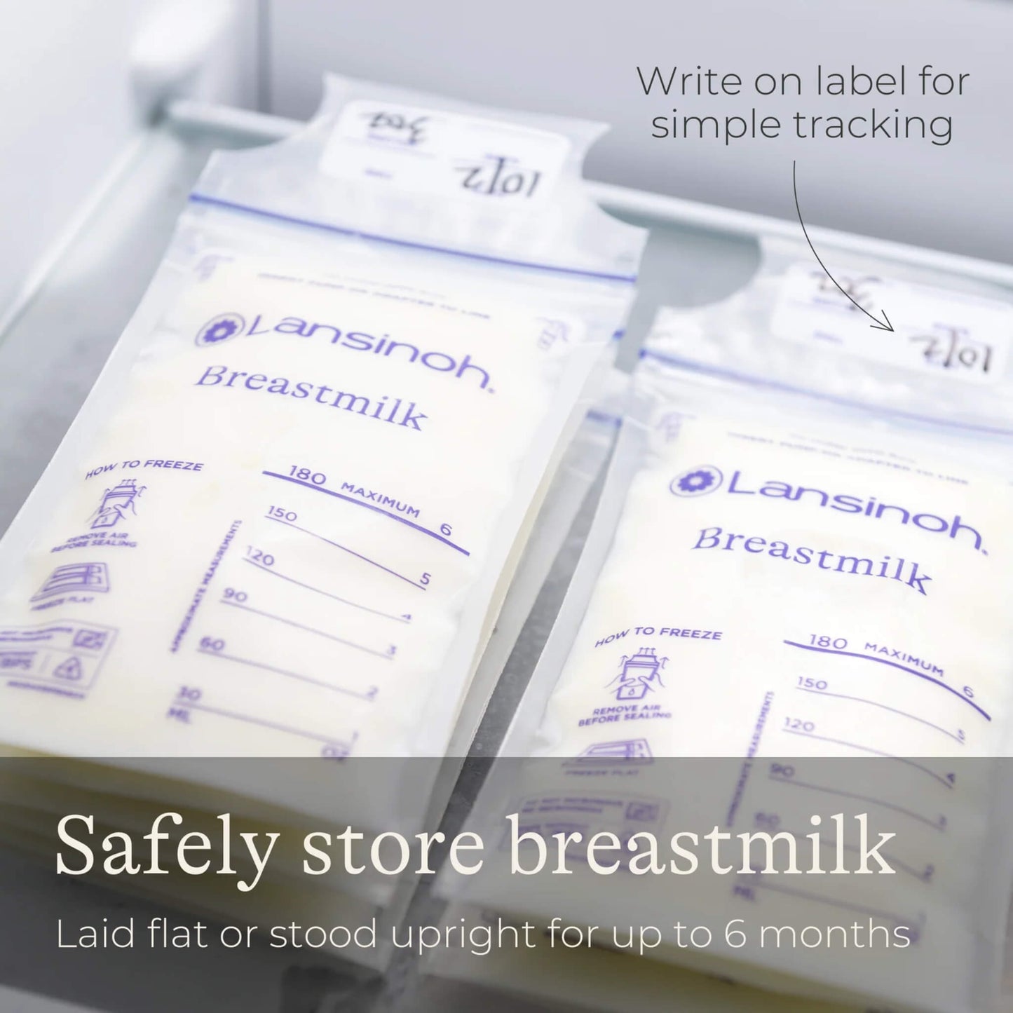 Two labelled breastmilk storage bags stored flat inside a freezer drawer with handwritten date labels visible for organised milk storage.