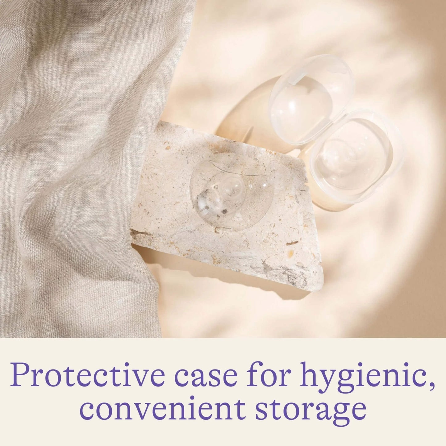 Open protective storage case with transparent nipple shields arranged on a stone surface beside soft fabric.