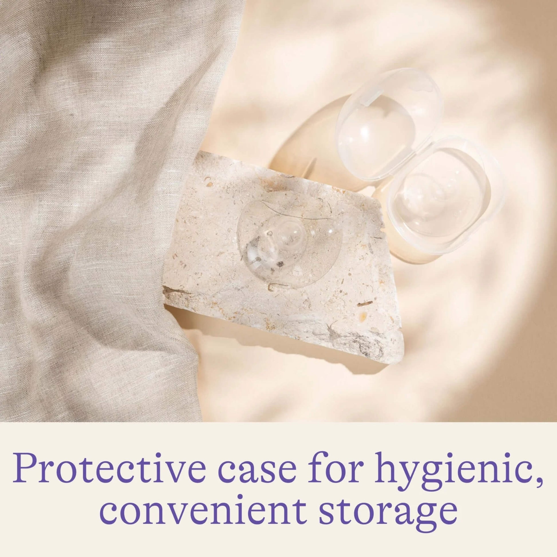 Open protective storage case with transparent nipple shields arranged on a stone surface beside soft fabric.