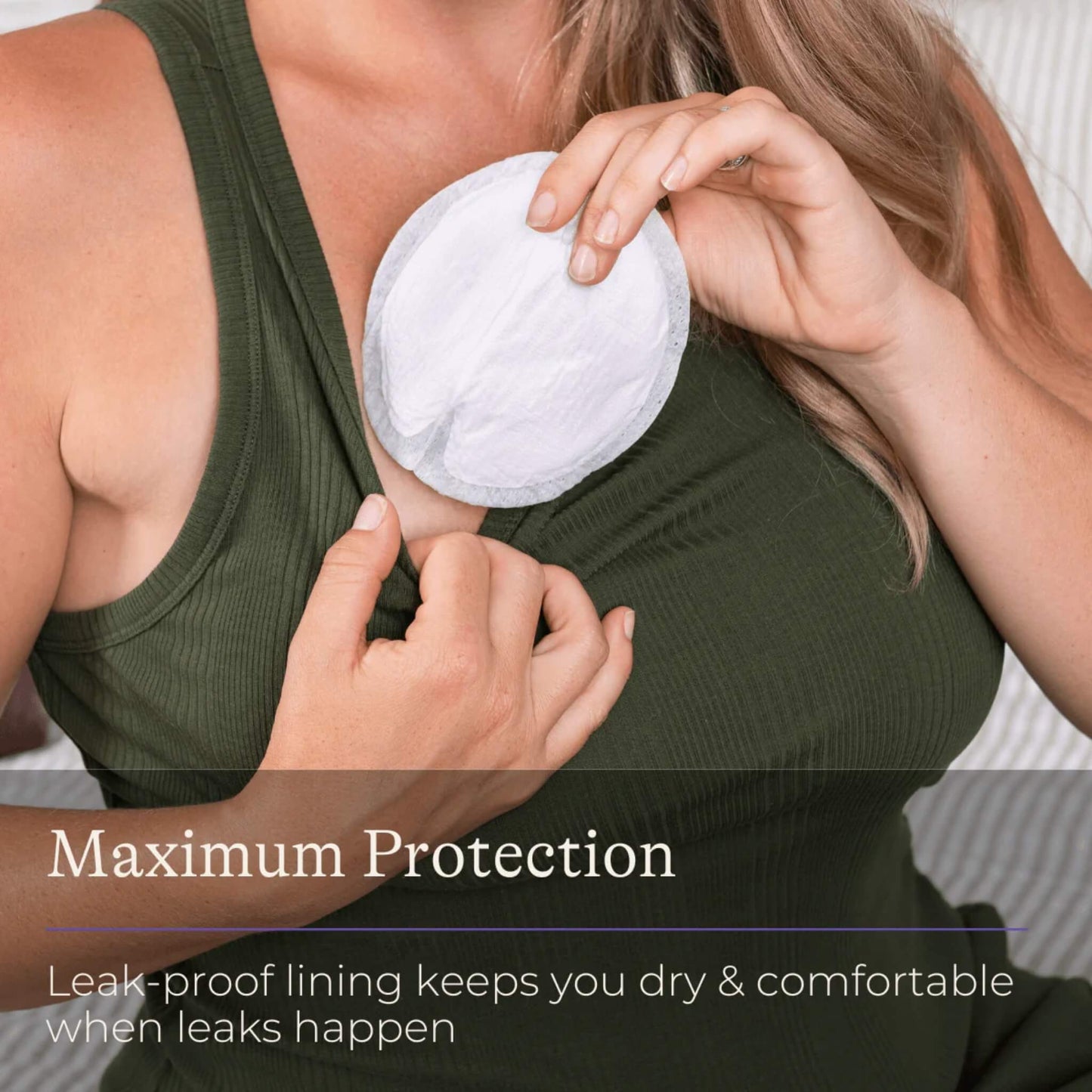 Pregnant woman fitting a disposable breast pad into her nursing bra for a secure, non-slip fit.