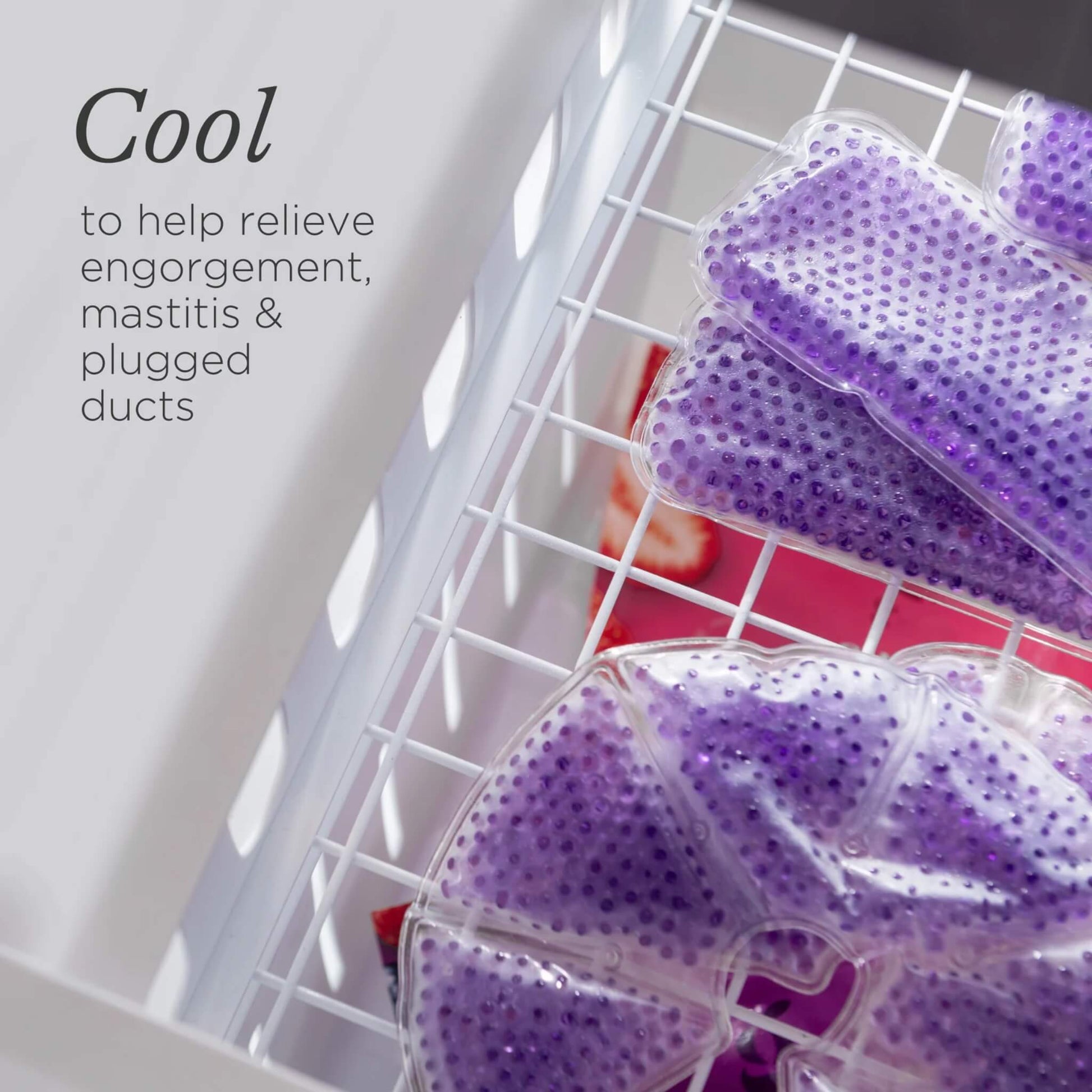 Purple reusable breast therapy packs resting inside a freezer drawer, demonstrating cold use for breastfeeding comfort and cooling relief.