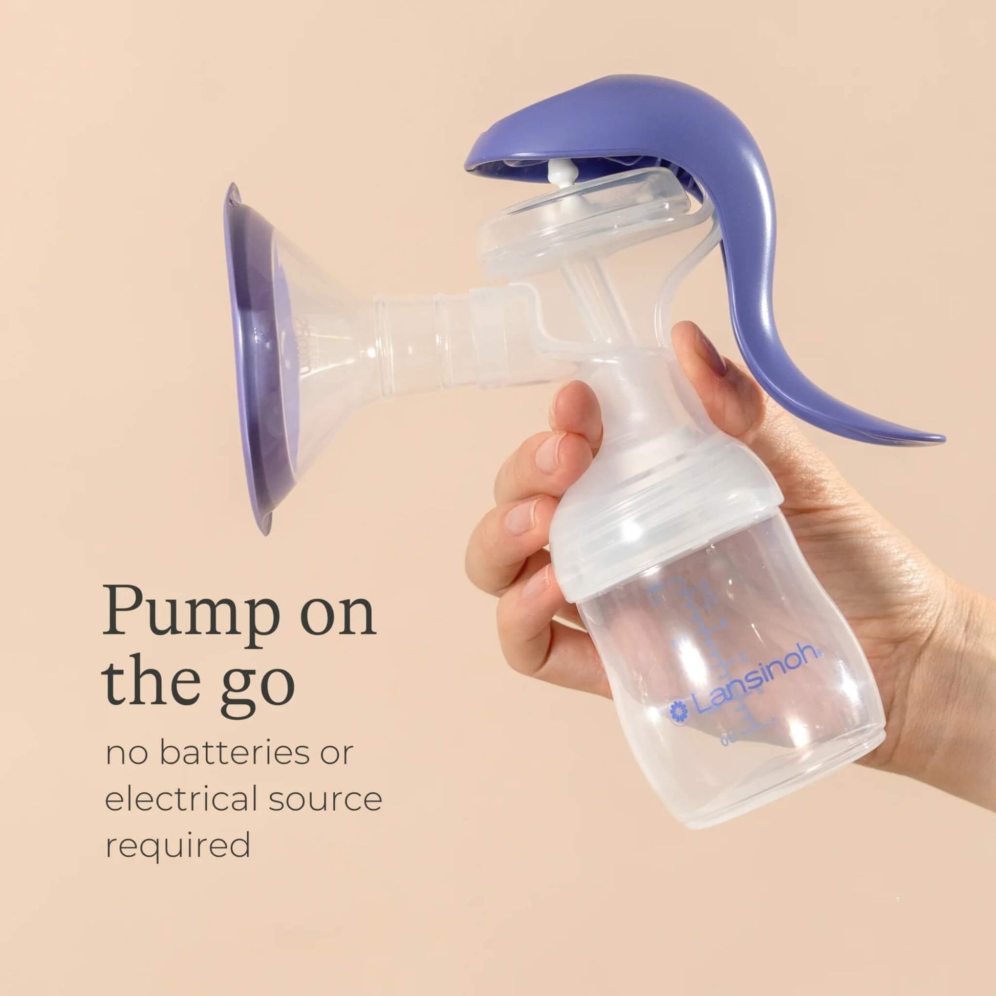 Hand holding the assembled manual breast pump upright, showing lightweight, cordless design suitable for pumping anywhere.