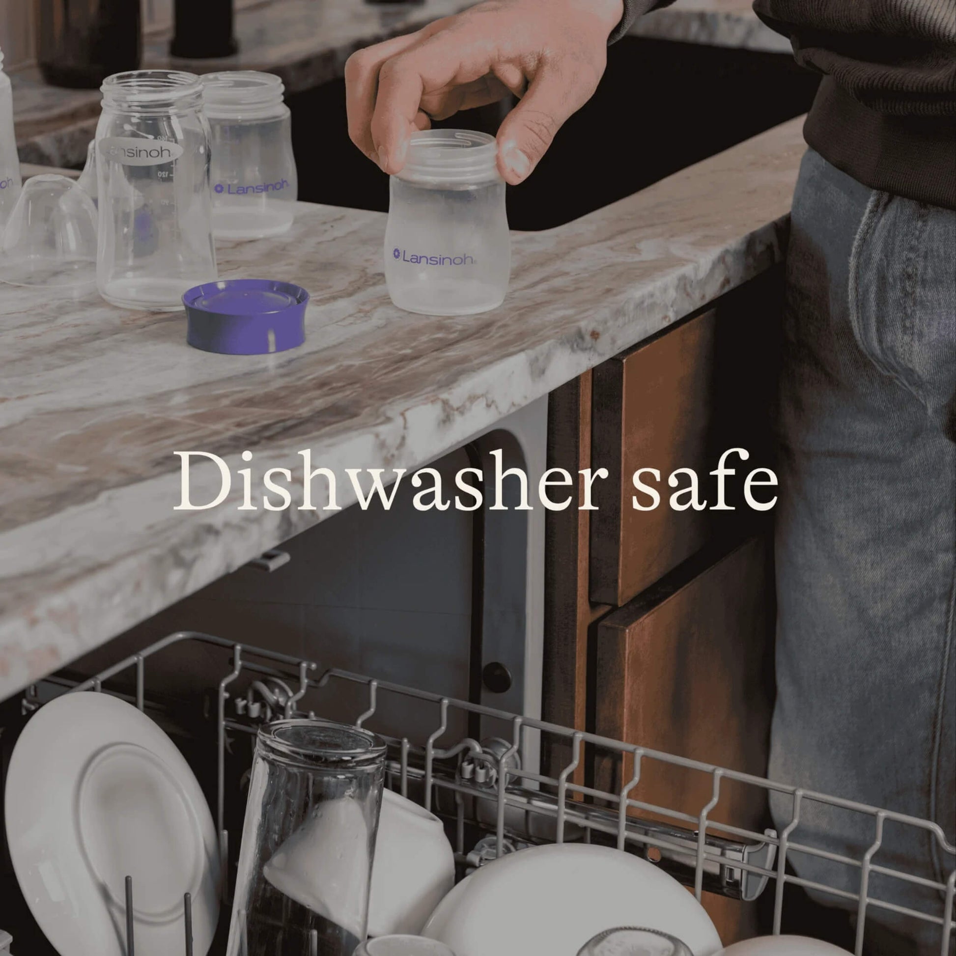 Person placing a breastmilk storage bottle beside an open dishwasher with additional bottles and lids shown for dishwasher-safe cleaning.