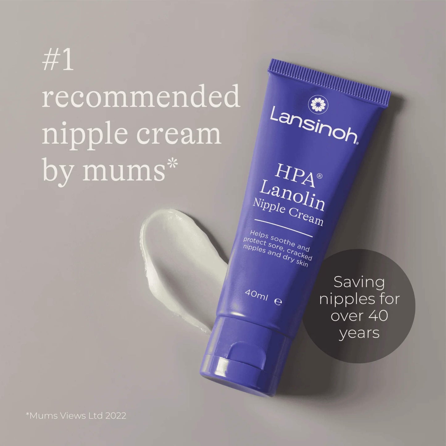 Close-up of a tube of nipple cream placed beside a small smear of cream on a neutral background.