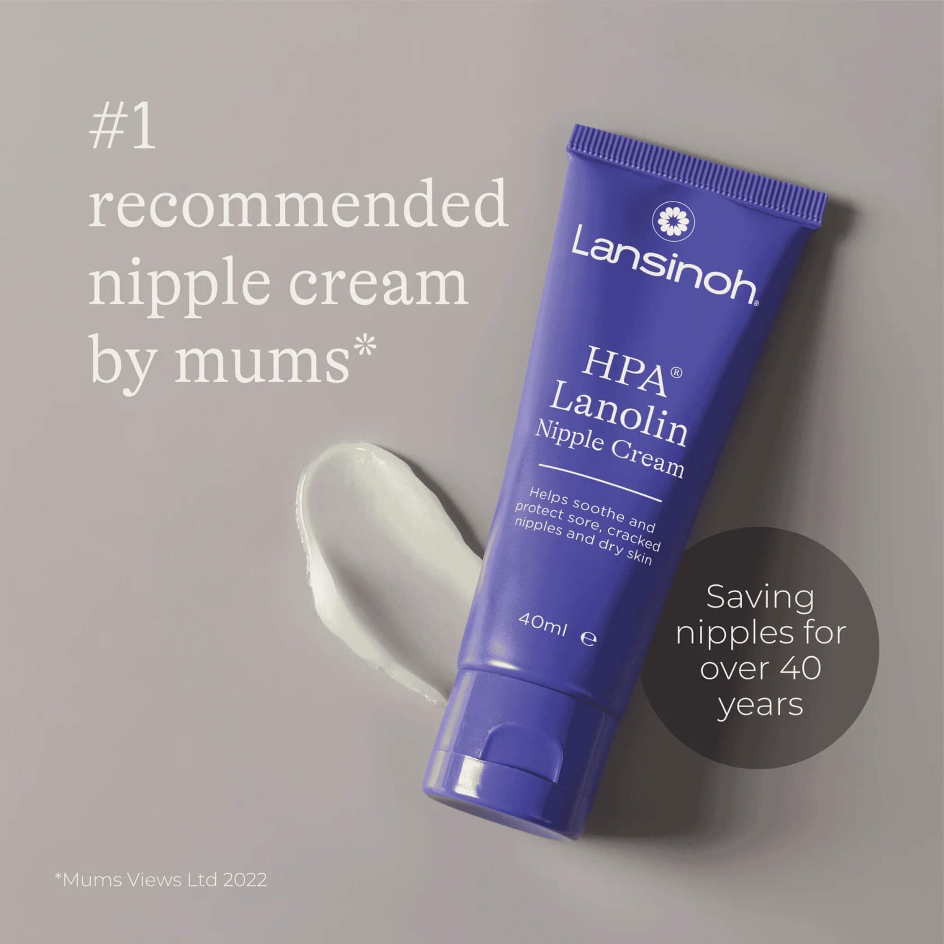 Close-up of a tube of nipple cream placed beside a small smear of cream on a neutral background.