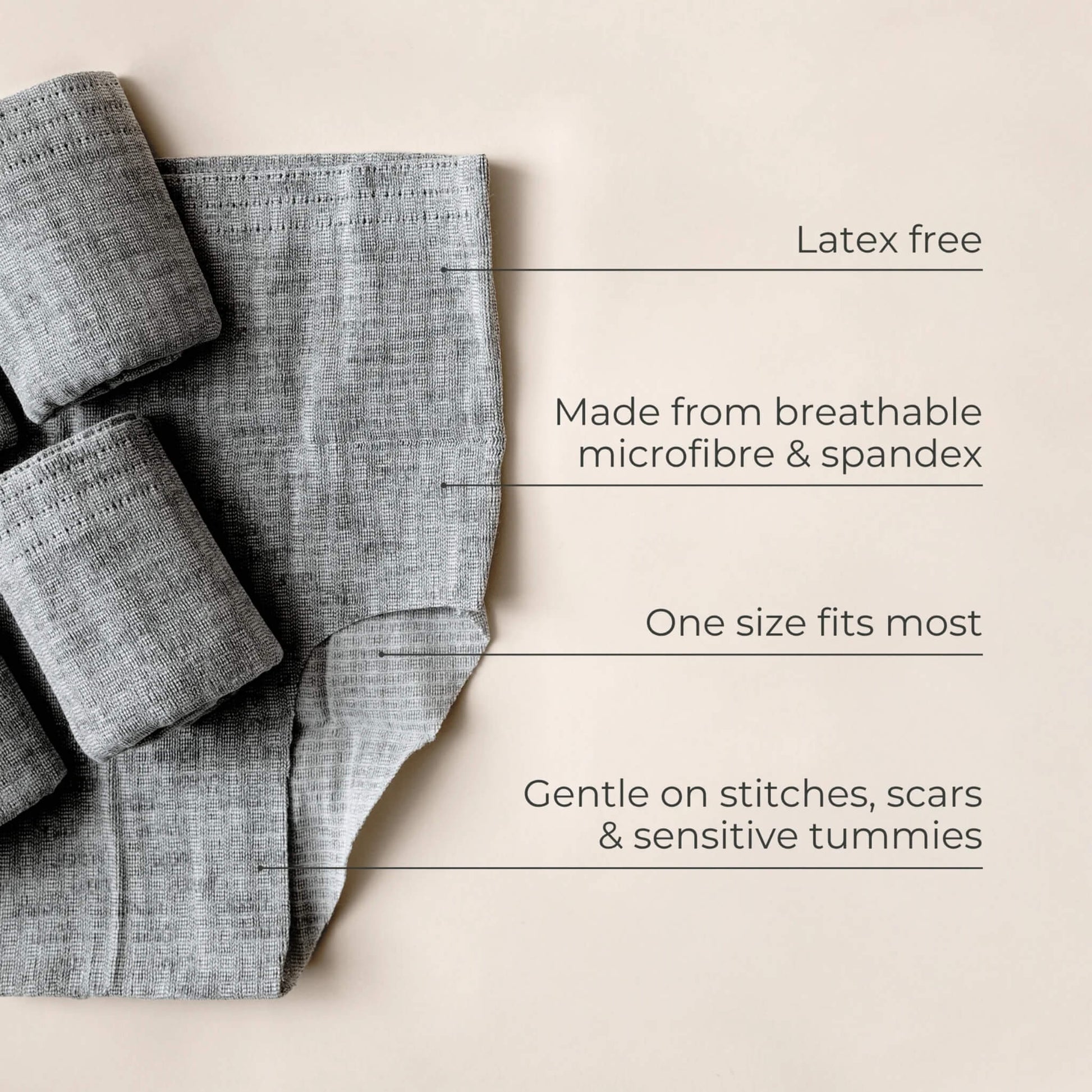 Folded grey postpartum underwear laid flat with labelled features highlighting breathable microfibre and spandex fabric, latex-free construction and a one-size-fits-most design.
