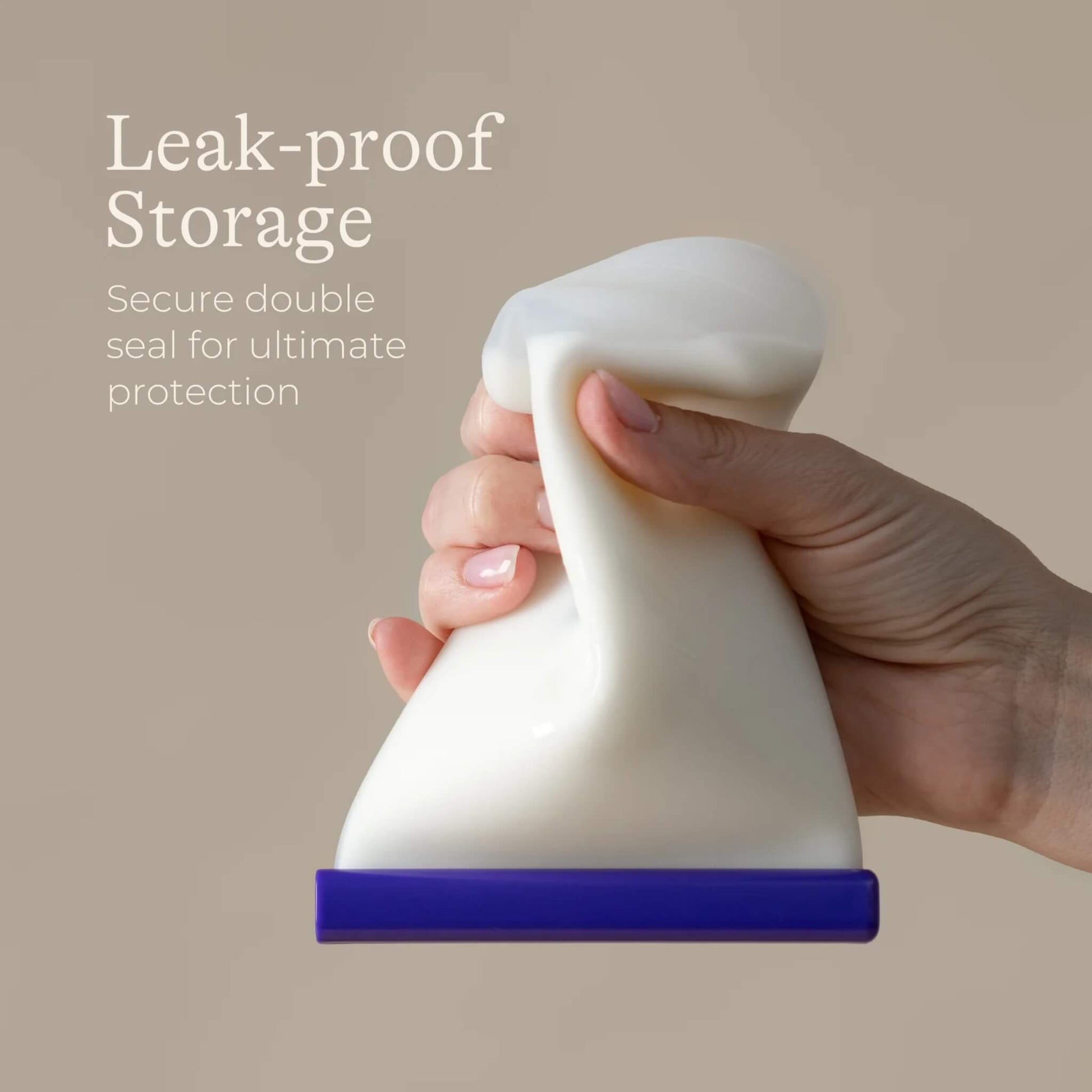 Close-up of a hand squeezing a filled silicone milk storage bag to demonstrate flexible leak-resistant material and secure sealing.