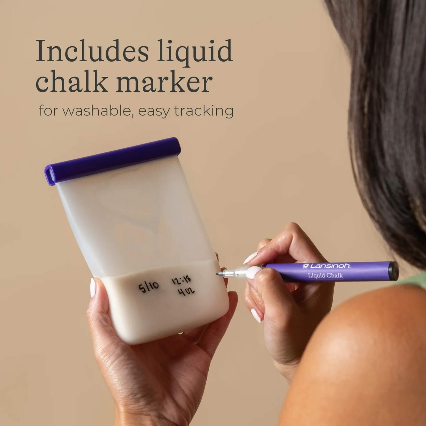 Person writing date and storage details onto a reusable silicone breastmilk storage bag using a washable liquid chalk marker.