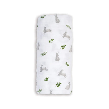 Lulujo Cotton Muslin Swaddle in the Bunnies design, neatly rolled to show its soft white fabric with light grey bunnies and small green leaves.