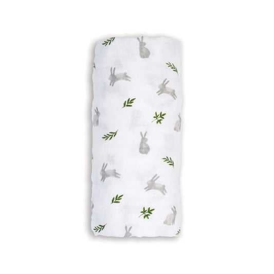 Lulujo Cotton Muslin Swaddle in the Bunnies design, neatly rolled to show its soft white fabric with light grey bunnies and small green leaves.