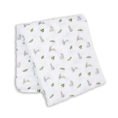 Lightweight muslin swaddle folded flat, showing a repeating pattern of grey bunnies and green leaves across the white cotton fabric.
