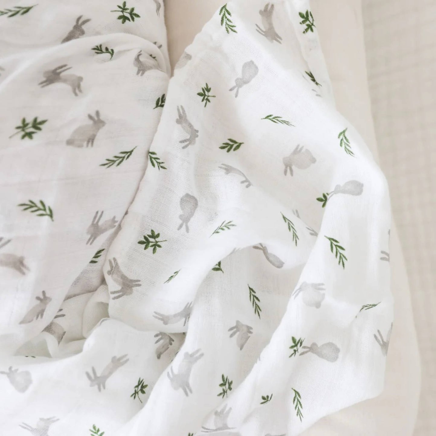 Close-up of the muslin fabric showing the delicate weave and detailed bunny and leaf design.